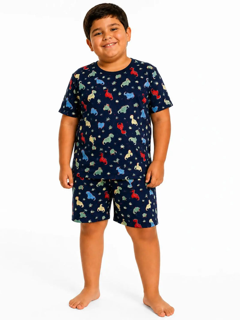 Menino usando pijama infantil masculino de Suede azul marinho com estampa de dinossauros, blusa manga curta e bermuda sem bolso.
