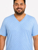 Homem usando pijama masculino longo azul estampado em malha PV, com camiseta de manga curta, gola V e calça comprida soltinha.
